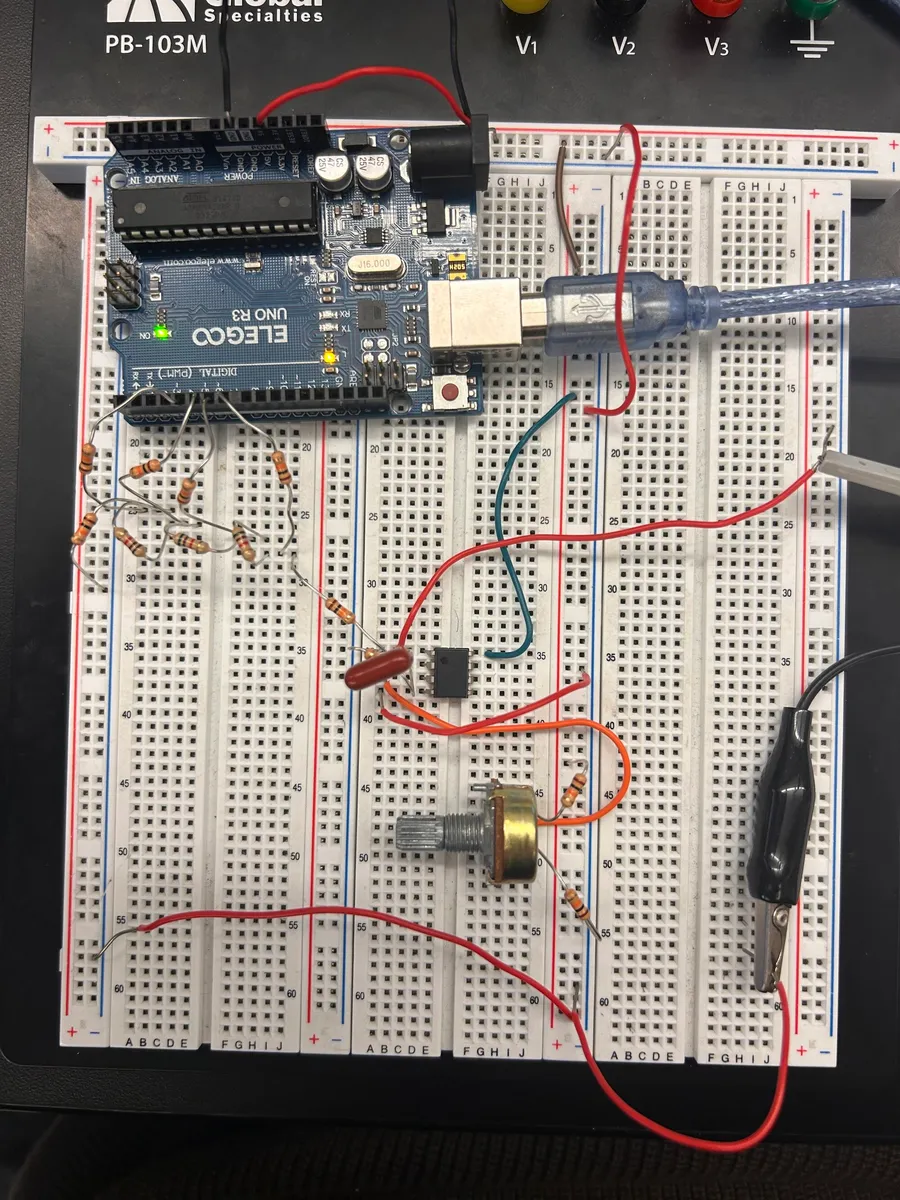 Breadboard with an Arduino Uno driving a resistor ladder, an op-amp and a potentiometer